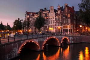 Twilight view of one of the most attractive canal houses in Amsterdam, Netherlands. This particulat photo was taken at the intersection between Keizersgracht (Emperor's canal) and Leidsegracht street and canal. On the left, the tower of Westerkerk (Western church) is visible. HDR image of 3 long exposures.
